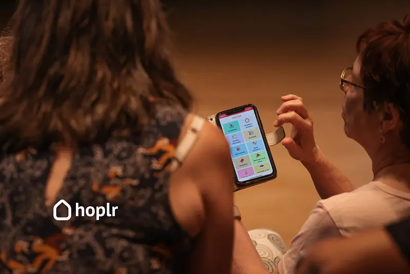 Eine Frau sieht sich die Hoplr-App auf ihrem Smartphone an.