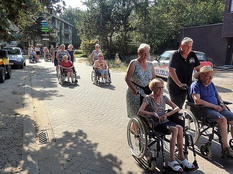 buren en familie gaan samen op stap, velen van hen zitten in een rolstoel